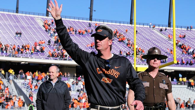 Oklahoma State Cowboys head coach Mike Gundy waves to fans.