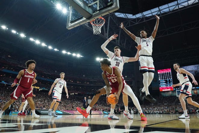 Apr 6, 2024; Glendale, AZ, USA; Alabama Crimson Tide forward Nick Pringle (23) looks to pass away from Connecticut Huskies center Donovan Clingan (32) and Connecticut Huskies guard Stephon Castle (5) in the semifinals of the men's Final Four of the 2024 NCAA Tournament at State Farm Stadium. Mandatory Credit: Robert Deutsch-USA TODAY Sports