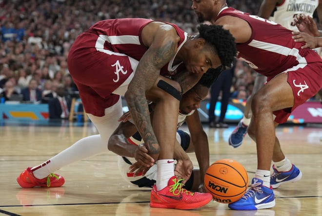 Apr 6, 2024; Glendale, AZ, USA; Alabama Crimson Tide forward Nick Pringle (23) battles for a loose ball on the floor against Connecticut Huskies guard Tristen Newton (2) in the semifinals of the men's Final Four of the 2024 NCAA Tournament at State Farm Stadium. Mandatory Credit: Robert Deutsch-USA TODAY Sports