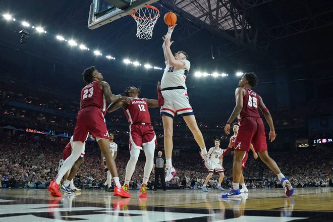 Apr 6, 2024; Glendale, AZ, USA; Connecticut Huskies center Donovan Clingan (32) shoots the ball against the Alabama Crimson Tide during the first half in the semifinals of the men's Final Four of the 2024 NCAA Tournament at State Farm Stadium. Mandatory Credit: Bob Donnan-USA TODAY Sports