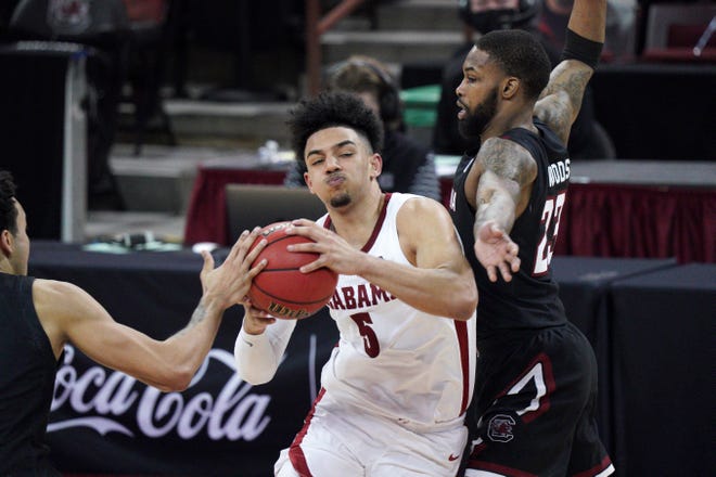 Alabama guard Jaden Shackelford (5) drives to the hoop against South Carolina guard Seventh Woods (23) during the second half of an NCAA college basketball game Tuesday, Feb. 9, 2021, in Columbia, S.C. Alabama won 81-78. (AP Photo/Sean Rayford)