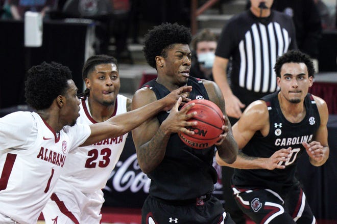 South Carolina forward Jalyn McCreary (4) drives to the hoop against Alabama forward Herbert Jones (1) and John Petty Jr. (23) during the first half of an NCAA college basketball game Tuesday, Feb. 9, 2021, in Columbia, S.C. (AP Photo/Sean Rayford)