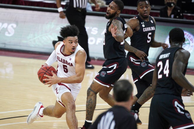 Alabama guard Jaden Shackelford (5) drives to the hoop against South Carolina guard Seventh Woods, right, during the second half of an NCAA college basketball game Tuesday, Feb. 9, 2021, in Columbia, S.C. Alabama won 81-78. (AP Photo/Sean Rayford)