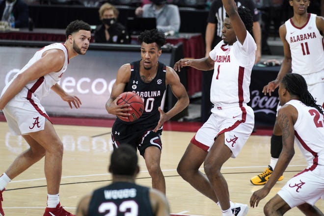 South Carolina guard AJ Lawson (00) drives between Alabama forward Herbert Jones (1) and Alex Reese, left, during the first half of an NCAA college basketball game Tuesday, Feb. 9, 2021, in Columbia, S.C. (AP Photo/Sean Rayford)